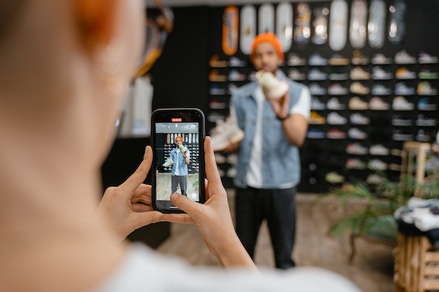 a-man-holding-rubber-shoes-having-his-photo-taken